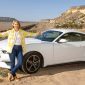 Samantha Brown in front of her Ford Mustang on Route 66 in New Mexico